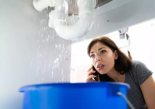 women-doing-emergency-plumber-phone-call-in-kitchen